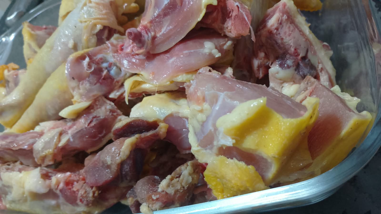 Pedaços de frango caipira com gordura amarelinha